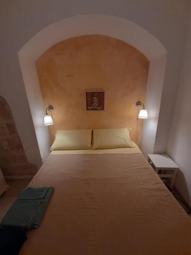 Una cama en una habitación con dos lámparas. en Borgo Antico, en Monopoli