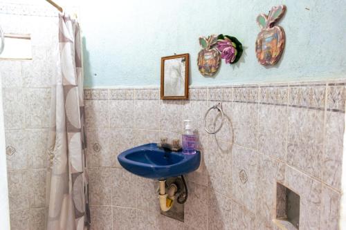 a bathroom with a blue sink and a shower at El Castillo de Panajachel 6ppl in Panajachel