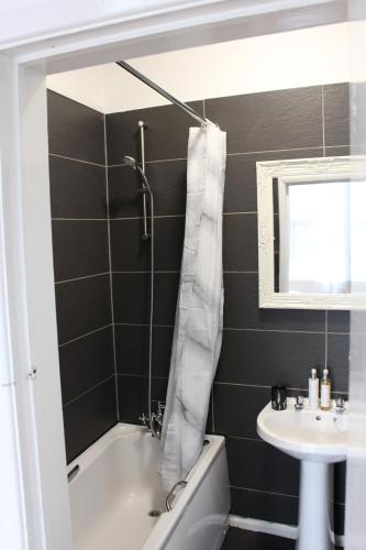 a bathroom with a white tub and a sink at Flat 5, Westhill in Leeds