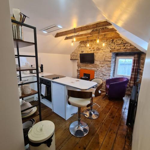 a kitchen with a table and chairs in a room at Ness City Cottage - Attic Apartment in Inverness