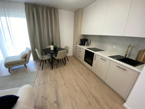 a kitchen and dining room with a table and chairs at Lazur Seven in Gdańsk