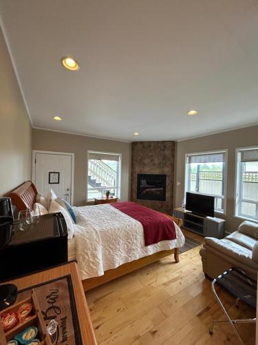 a bedroom with a large bed and a fireplace at Pacific Rim Guest Lodge - Adults Only in Ucluelet