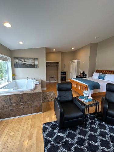 a bedroom with a king sized bed and a tub at Pacific Rim Guest Lodge - Adults Only in Ucluelet