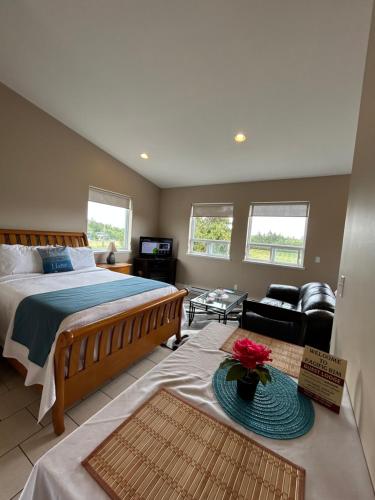 a bedroom with a bed and a living room at Pacific Rim Guest Lodge - Adults Only in Ucluelet