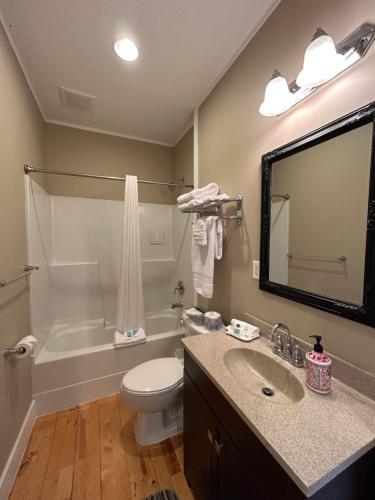 a bathroom with a sink and a toilet and a tub at Pacific Rim Guest Lodge - Adults Only in Ucluelet