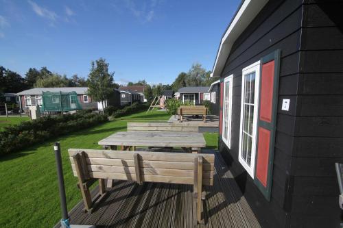 a group of picnic tables on the side of a building at Chalet park Kroondomein Giethoorn in Giethoorn