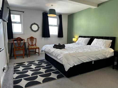 a bedroom with a large bed and a table and chairs at Cosy entire apartment super king bed near town center in Colchester