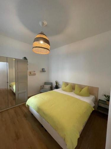 una camera con letto giallo e lampadario a braccio di Loft inmitten der Altstadt a Wangen im Allgäu