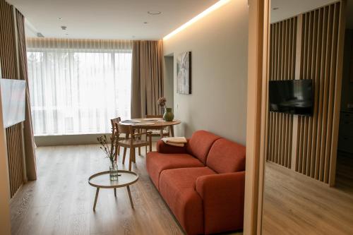 a living room with a couch and a table at Charming Apartment In Zeimena's Street in Kaunas