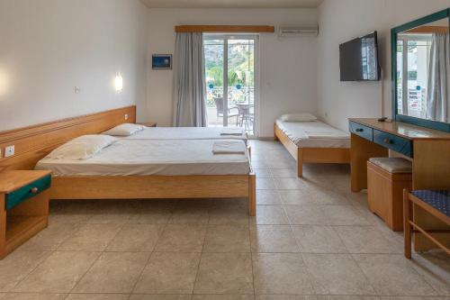 a bedroom with two beds and a tv and a mirror at Faliraki Dream Apartments & Studios in Kallithea Rhodes