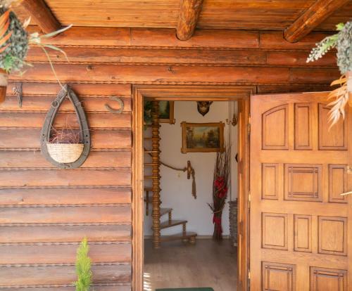 Casa de madera con puerta y silla en Domek myśliwski na wsi en Przemyśl