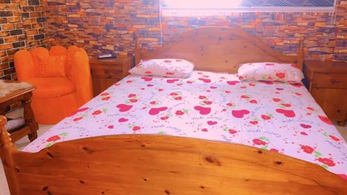 a bedroom with a wooden bed with flowers on it at La fierté in Ziguinchor