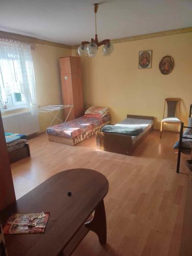 a living room with several beds and a table at Kwatery -pokoje pracownicze, tanie noclegi in Białogard