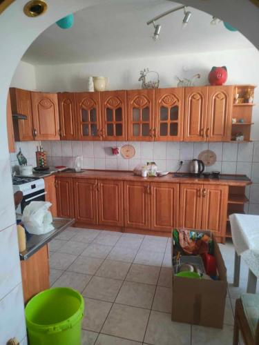 - une cuisine avec des placards en bois et une boîte au sol dans l'établissement Kwatery -pokoje pracownicze, tanie noclegi, à Białogard