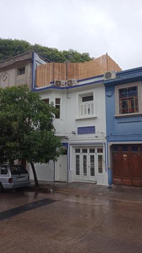 una casa blu e bianca con una macchina parcheggiata di fronte di Casa Triada a Montevideo