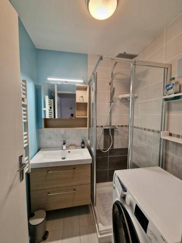 une salle de bain avec douche et lavabo dans l'établissement Rez-de-jardin près de la mer, à Cabourg