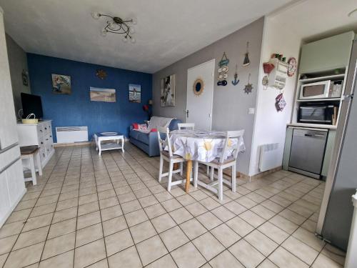 une cuisine et un salon avec une table et des chaises dans l'établissement Rez-de-jardin près de la mer, à Cabourg