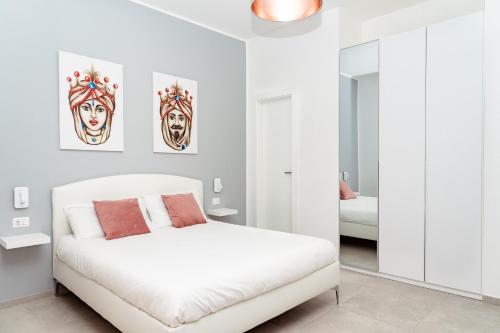 a white bedroom with a bed and a mirror at La maison de tante Rosa in Syracuse