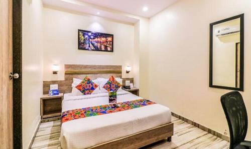 um quarto com uma cama e uma cadeira em New Aksha International By Glitz Hotels em Mumbai