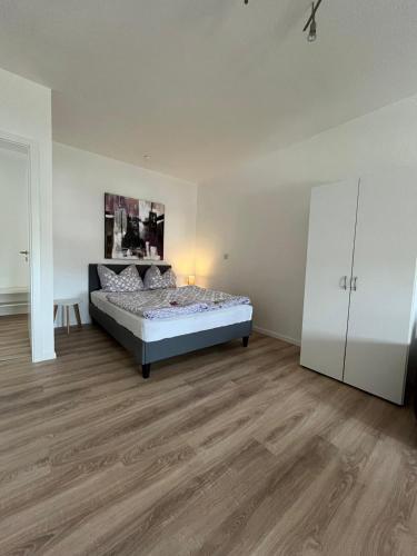 1 dormitorio con 1 cama y armario blanco en 1 Raum Wohnung in ruhiger Lage, en Limbach - Oberfrohna