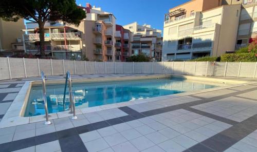 een zwembad voor sommige appartementsgebouwen bij STUDIO VUE PORT PISCINE PARKING in Cap d'Agde