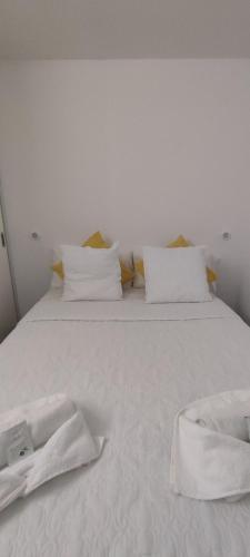 - un lit blanc avec des draps et des oreillers blancs dans l'établissement Apartamento La Mar, à Puerto de Santiago