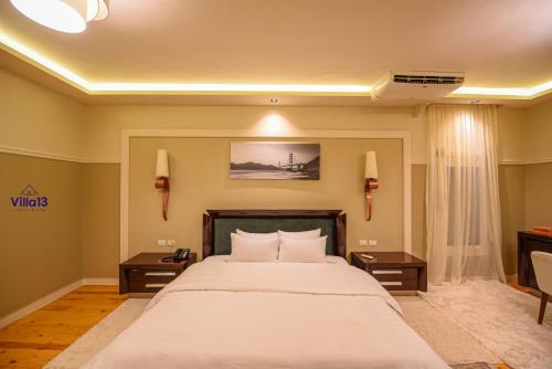 a bedroom with a large white bed with two tables at Villa 13 Luxury suites in Cairo