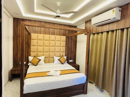 a bedroom with a bed and a ceiling fan at Airport Hotel Relax Inn in Nagpur