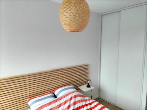 a bedroom with a bed with a wooden head board at T2 proche lac in Annecy