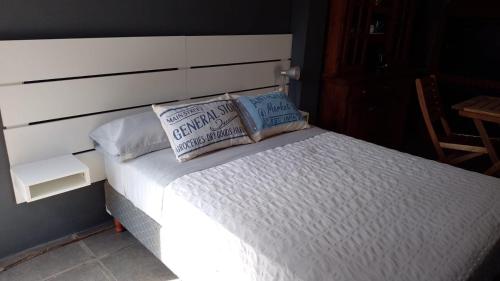 a bed with two pillows on top of it at Casa dique Pet Friendly in Tandil