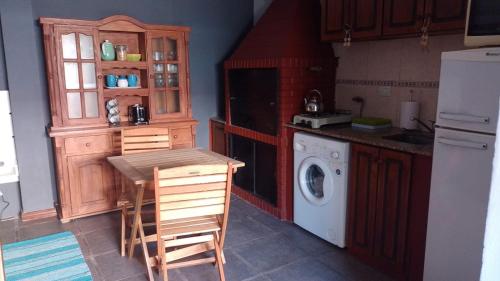 a kitchen with a table and a washing machine at Casa dique Pet Friendly in Tandil