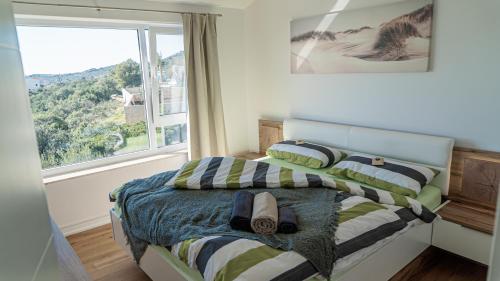 - une chambre avec un lit doté d'oreillers à rayures et une fenêtre dans l'établissement Villa Alacinda, à Rogoznica