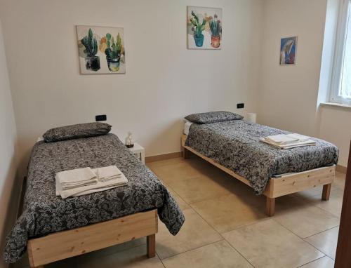 Dos camas en un dormitorio con dos toallas. en INES HOME tra lago e montagna - Lago d'Iseo en Pisogne
