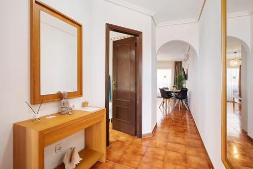 サンミゲル・デ・アボナにあるTu hogar en Tenerife ,Parque Albatrosの鏡とテーブルのある廊下のある部屋