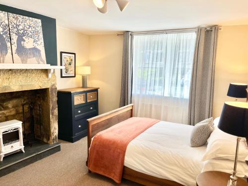 ein Schlafzimmer mit einem Bett und einem Kamin in der Unterkunft Inviting townhouse in Bedlington in Bedlington