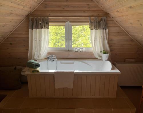 a large bath tub in a room with a window at Drewniany dom w cudownej okolicy in Brusy