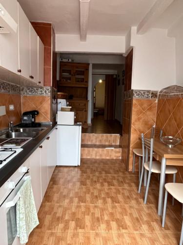 a kitchen with white cabinets and a wooden floor at Casa rural in Puebla de Don Fadrique