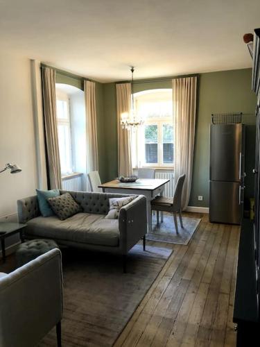 a living room with a couch and a table and a refrigerator at Schöner Wohnen im alten Rathaus in Achberg, See+Berge vor der Tür in Achberg