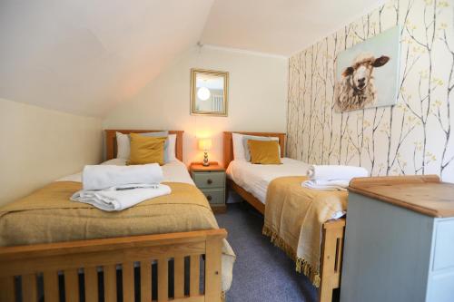 een slaapkamer op zolder met 2 bedden in een kamer bij Ferndale Cottage in Lynmouth