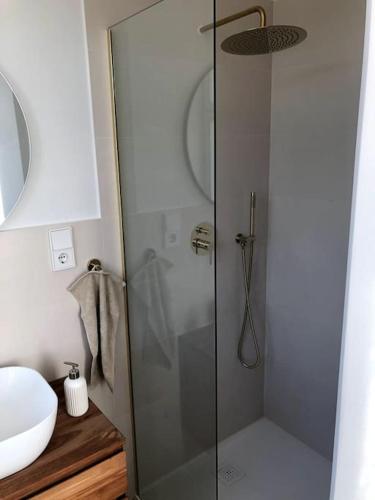 a shower with a glass door next to a sink at Schöner Wohnen im alten Rathaus in Achberg, See+Berge vor der Tür in Achberg