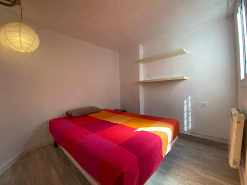 łóżko w pokoju z kolorowym kocem w obiekcie Cozy apartment in the city centre of Barcelona w Barcelonie