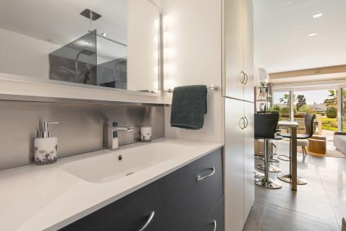 une salle de bain avec un lavabo et un miroir dans l'établissement Le Jardin des Sens naturiste, au Cap d'Agde