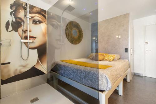 une chambre avec une grande peinture d'une femme dans l'établissement Le Jardin des Sens naturiste, au Cap d'Agde