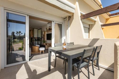 une table et des chaises sur le patio d'une maison dans l'établissement Le Jardin des Sens naturiste, au Cap d'Agde