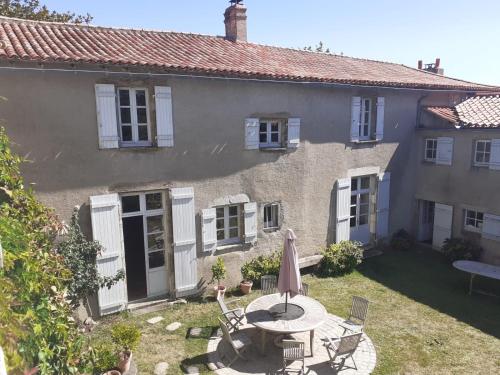 a house with a table and chairs in the yard at Logis de la Coudraye in Apremont