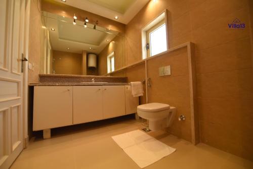 a bathroom with a toilet and a sink and a mirror at Villa 13 Luxury suites in Cairo
