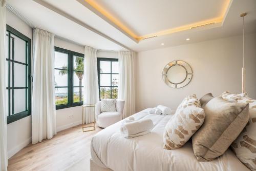 una camera bianca con un letto e una sedia di Villa Shakira, Sierra Blanca, Marbella a Marbella