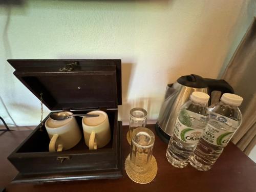 a coffee maker and water bottles on a table at Phu Jaya Floresta Resort by ALPHATEL PARTNER in Chiang Mai