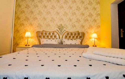 - une chambre avec un grand lit blanc et deux lampes dans l'établissement District One Villa with Private Courtyard and Terrace, à Bucarest