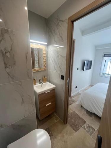 une salle de bain avec un lavabo et des toilettes et un lit dans l'établissement STRELIZIA - New central old Antibes for 4 AC, à Antibes